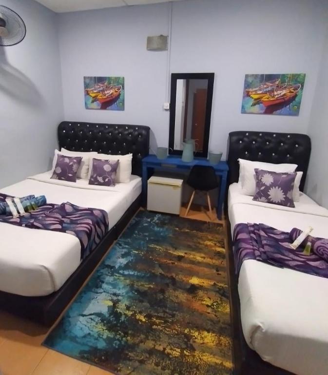 Postel nebo postele na pokoji v ubytování Ghazrin's Garuda Hotel