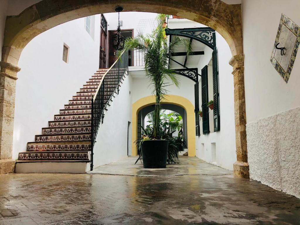 un corridoio vuoto con scale e una pianta in vaso di Hostal Pons a Palma de Mallorca