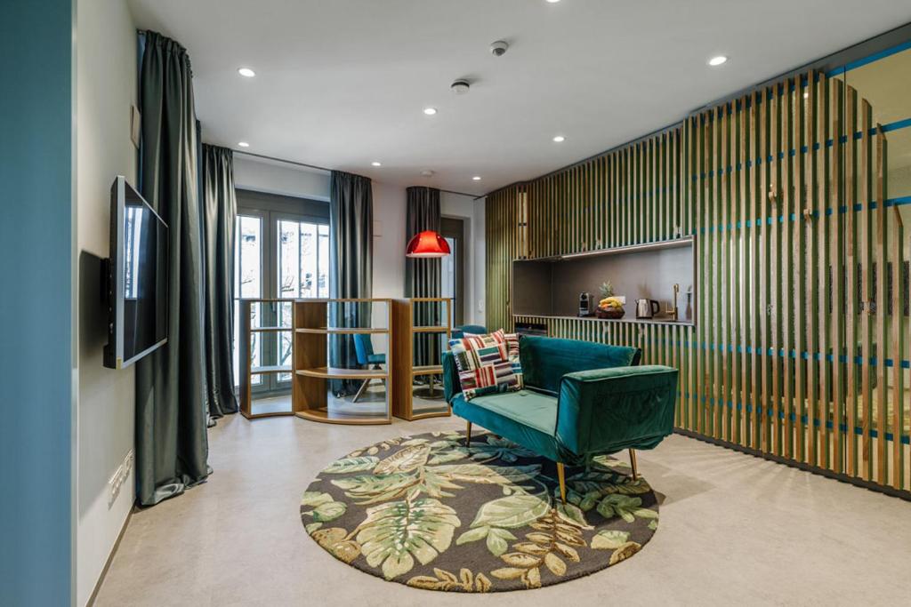 ein Wohnzimmer mit einem grünen Stuhl und einem Teppich in der Unterkunft Brucklyn Suites in Erlangen