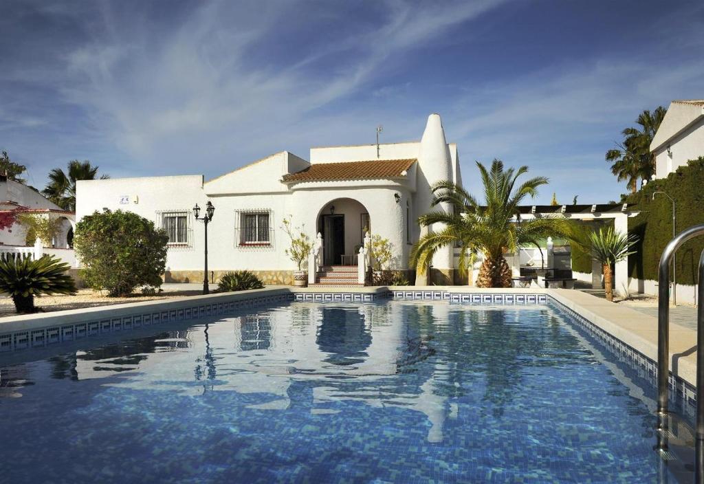 a villa with a swimming pool in front of a house at La Casa Del Sol in Torrevieja