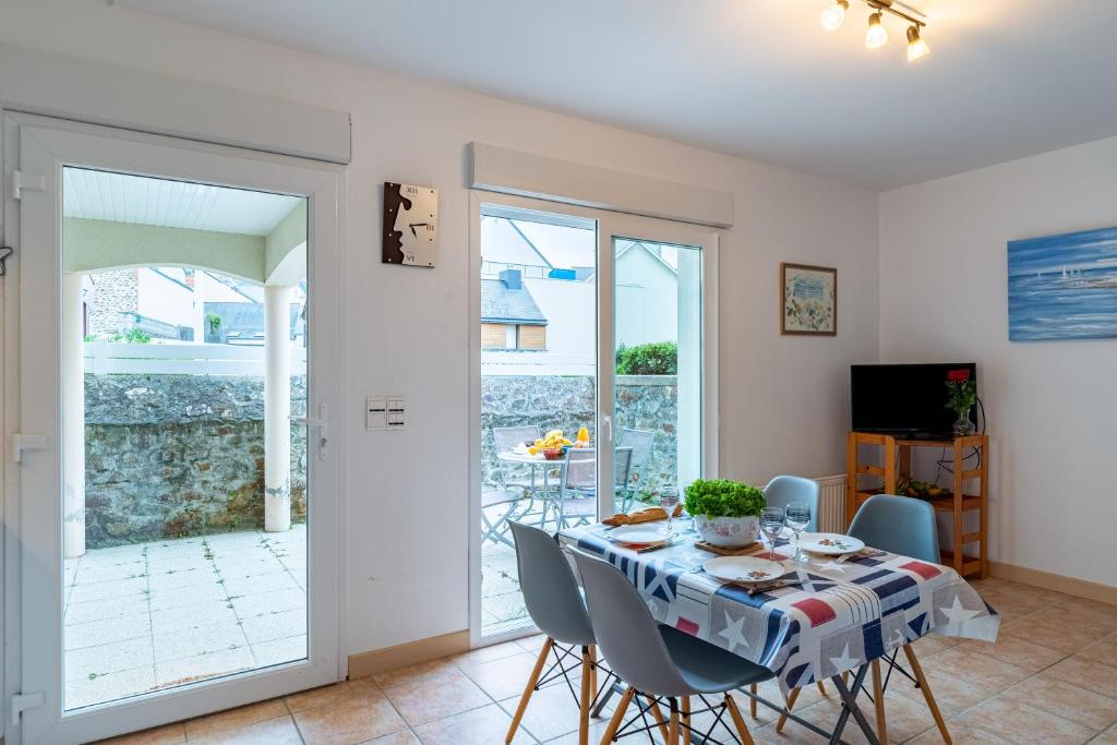 a dining room with a table and chairs at Les Voiles - appartement avec terrasse - plage à 50 m in Pléneuf-Val-André