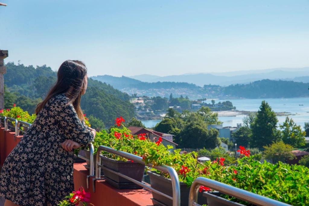 una mujer con un vestido de pie en un balcón con vistas en Villa Covelo, en Poio