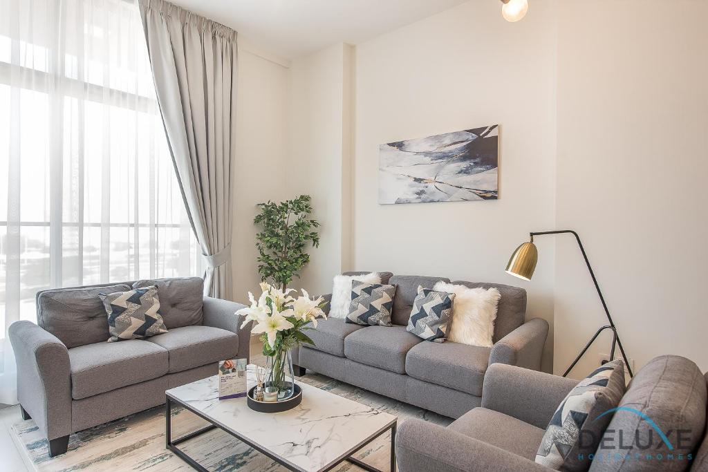 a living room with a couch and a table at Stunning 1BR at Prime Views Meydan by Deluxe Holiday Homes in Dubai