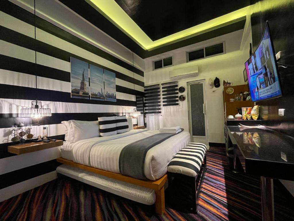 um quarto com uma cama grande e uma televisão em Italy Condotel Darasa em Tanauan