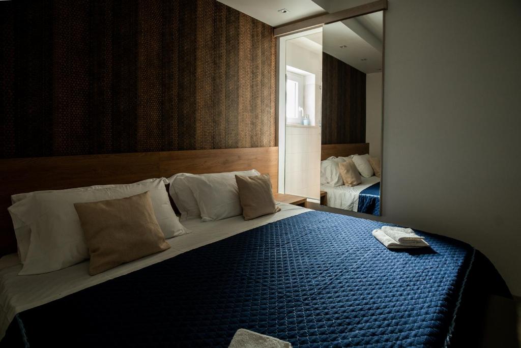 a bedroom with a large bed with a blue blanket at Gu Hotel in Guidonia