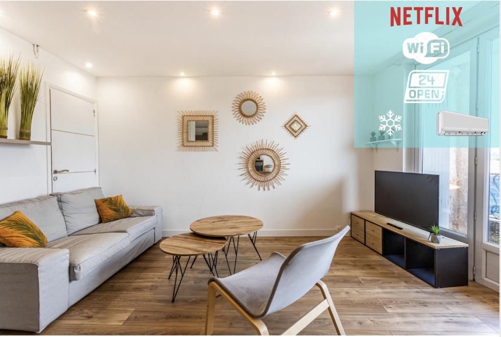 a living room with a couch and a table and a tv at **T3 **24h/24h**Internet** 12mn de Toulouse en Train** in Saint-Jory