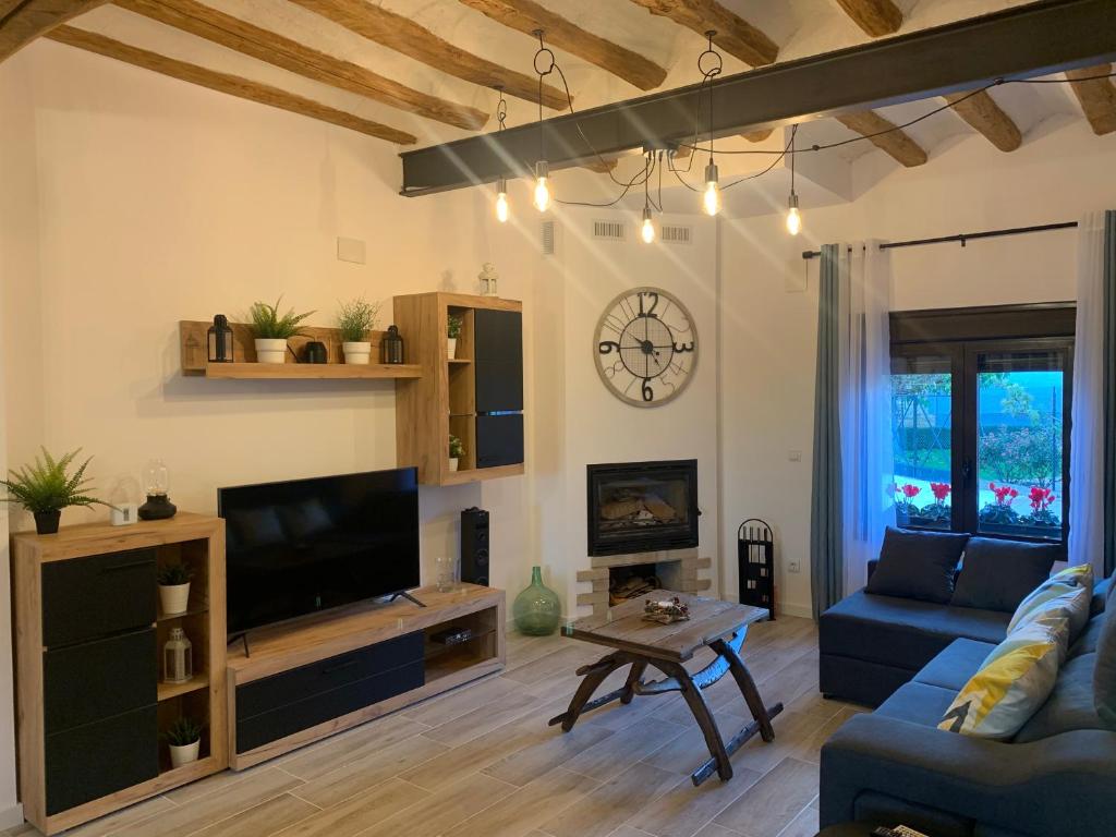 uma sala de estar com um sofá azul e uma televisão em Alojamiento con amplio salón y chimenea. em Valverde