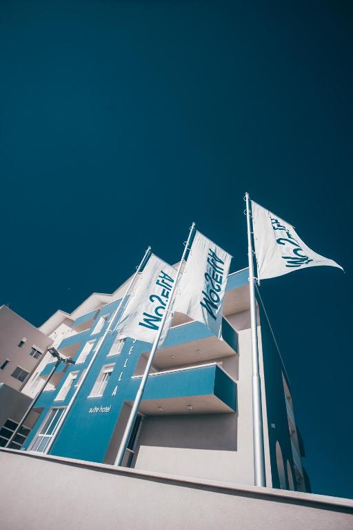 a building with two flags on top of it at Mosella Suite Hotel in Sottomarina
