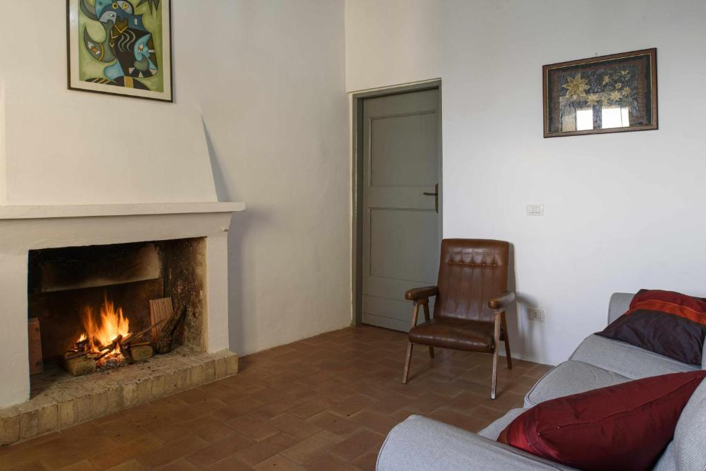 salon z kominkiem i krzesłem w obiekcie CASA LELLA Monte San Pietrangeli w mieście Monte San Pietrangeli