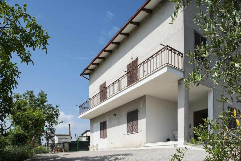 un edificio blanco con un balcón en el lateral. en LA CASA DE FASCIA' Contrada pescara valle, en Monte San Pietrangeli