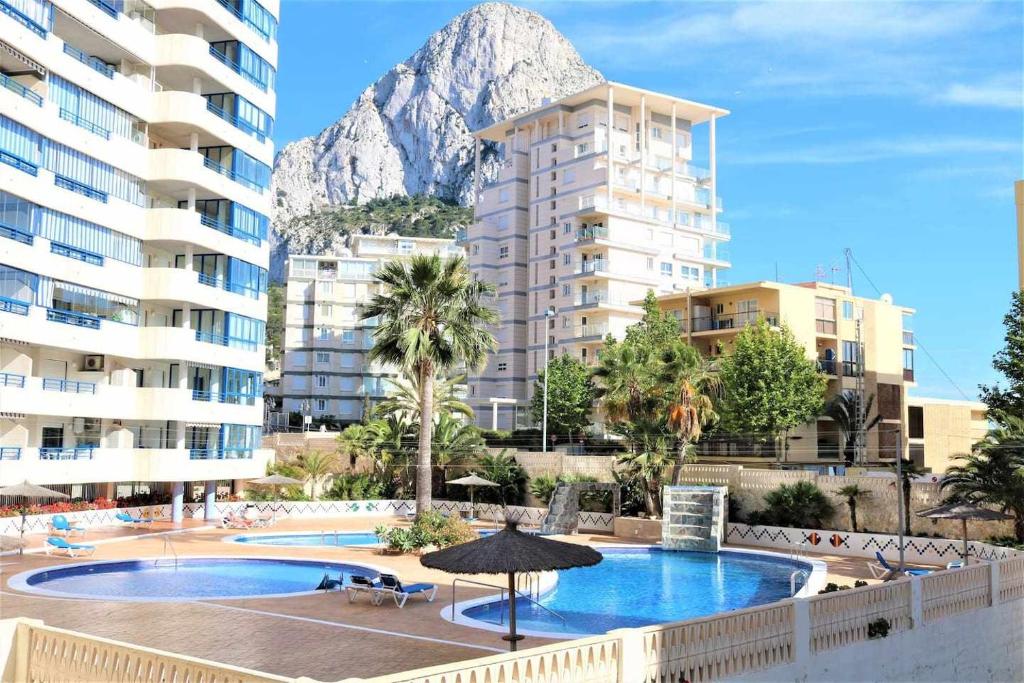 - une vue sur un hôtel avec une montagne en arrière-plan dans l'établissement 11B TB 2º línea de playa 1 dormitorio y wifi, à Calp