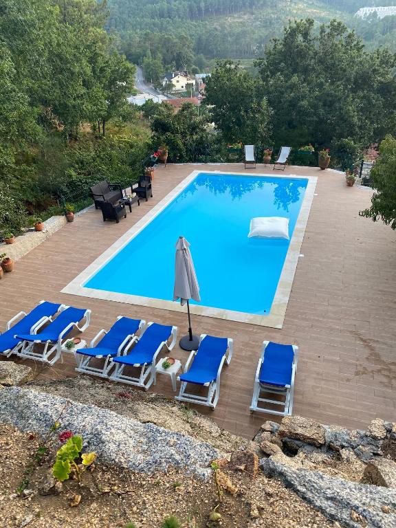 a swimming pool with lounge chairs and an umbrella at Villa de Fujacos in Valença