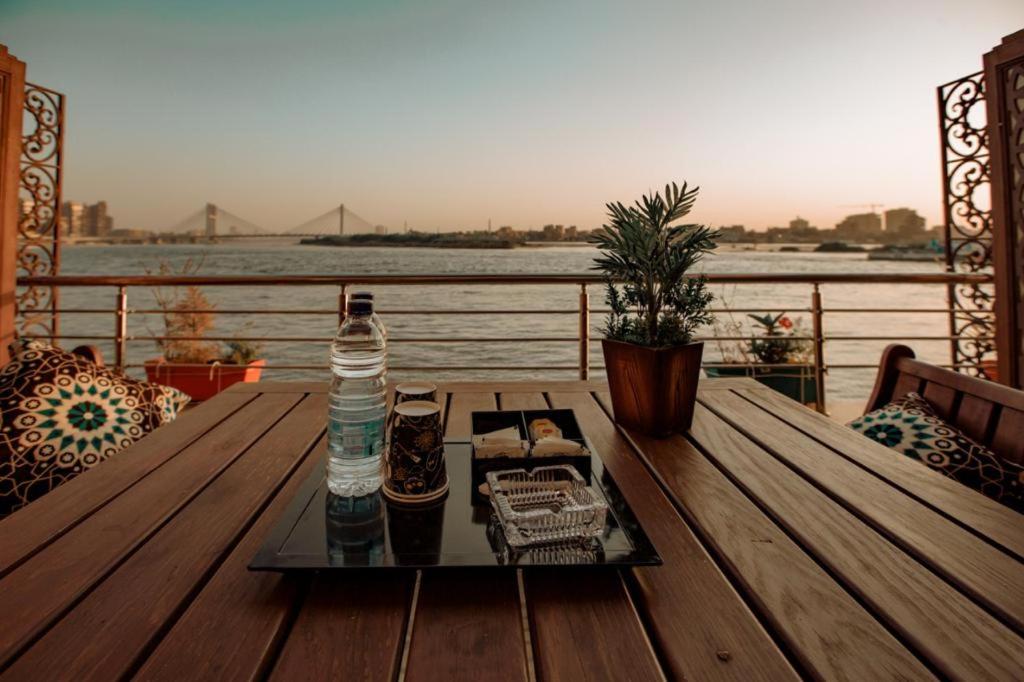 a bottle of water sitting on a wooden table on a balcony at Nile Transport Hotel in Cairo