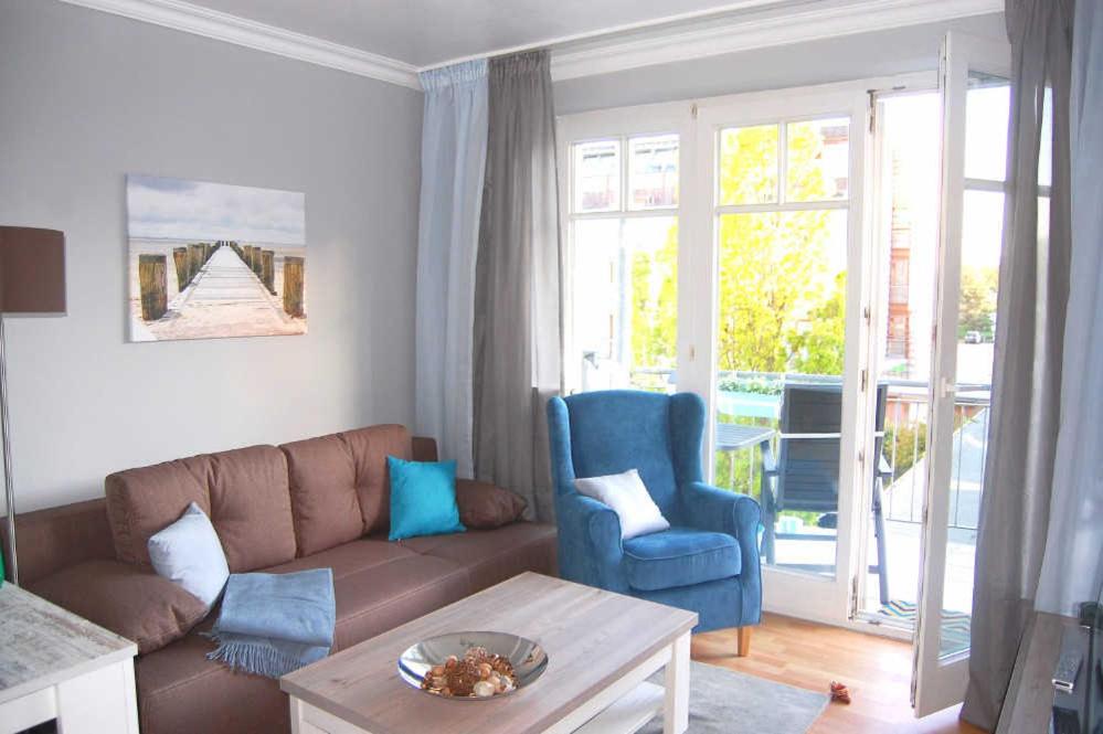 a living room with a brown couch and blue chairs at Haus Jahreszeiten Appartement Meeresrauscher by Unsere Urlaubszeit in Binz