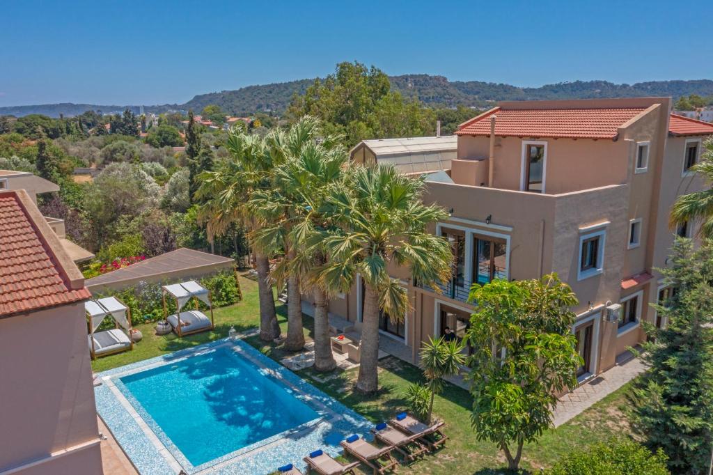 an aerial view of a house with a swimming pool and palm trees at Prestige Residence Rhodes in Ialyssos