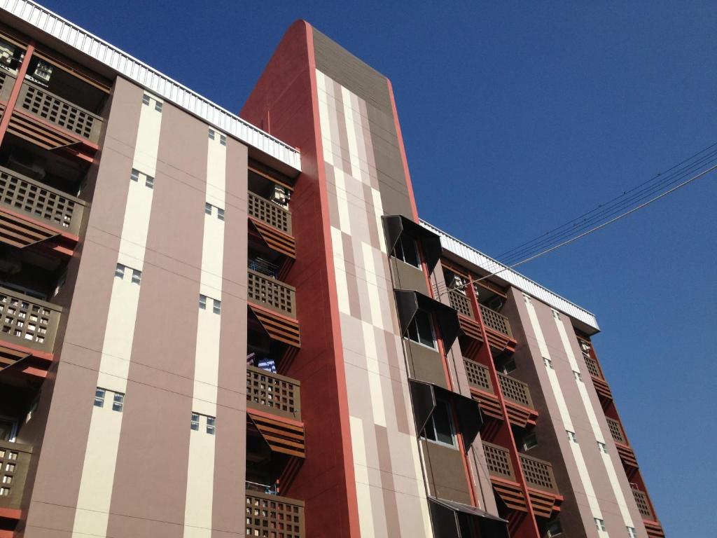 バンセーンにあるBurapha Bangsaen Garden Apartmentの窓がたくさんある赤と白の建物