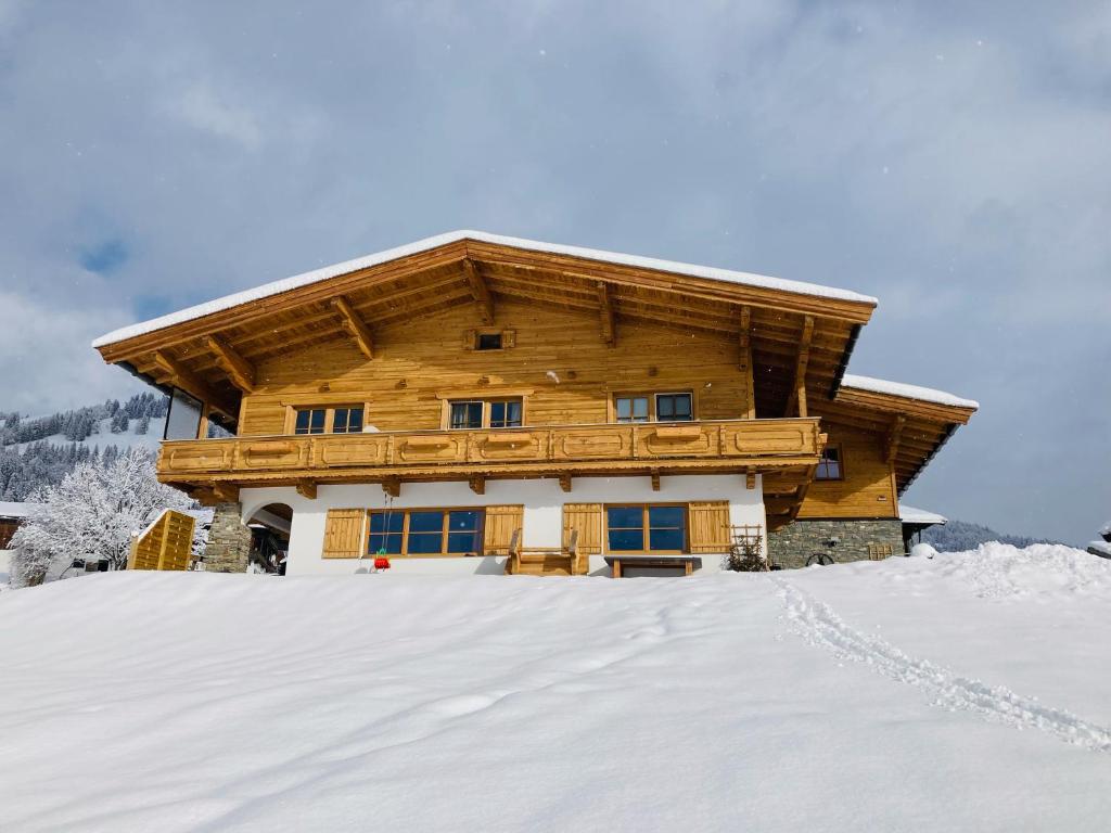 ein Blockhaus im Schnee in der Unterkunft Ferienwohnung Buchau in Fieberbrunn