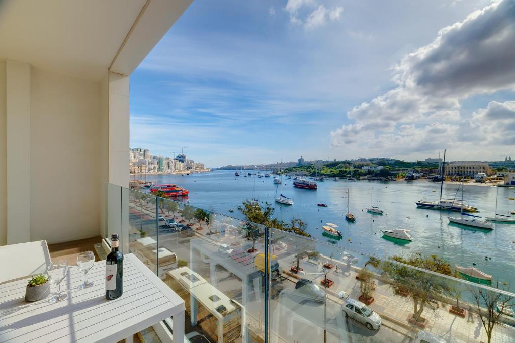 a balcony with a view of a harbor with boats at Superlative Apartment with Valletta and Harbour Views in Sliema