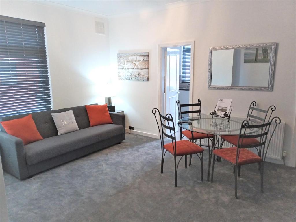 a living room with a couch and a table and chairs at St Annes Lodge Apartments, Lytham St Annes in Lytham St Annes