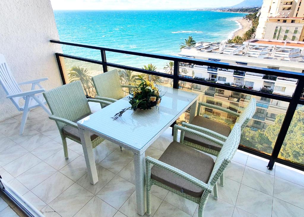 una mesa y sillas en un balcón con vistas al océano en Skol 701. One Bedroom Duplex with Exceptional Sea Views., en Marbella