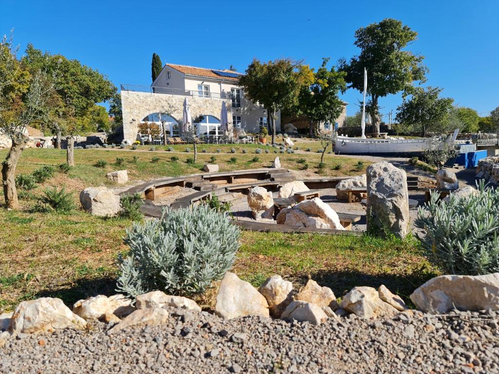 un parc avec des rochers et des arbres et un bâtiment dans l'établissement Boutique Resort OSMA, à Malinska