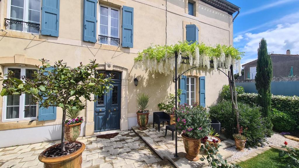 a house with plants in front of it at La Glycine Blanche in Pomas