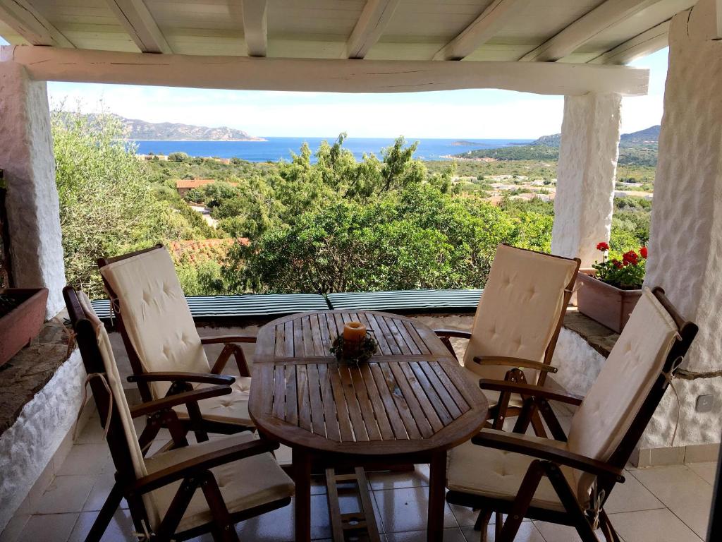 een tafel en stoelen op een veranda met uitzicht bij MichHouse in San Teodoro