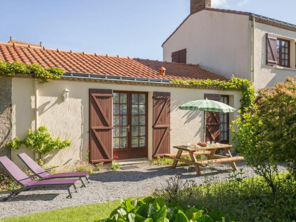 a patio with a table and chairs and an umbrella at Gîte Rouans, 2 pièces, 4 personnes - FR-1-306-830 in Rouans