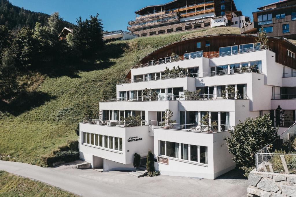 a large white building on top of a hill at VAYA Terrazena Serfaus in Serfaus