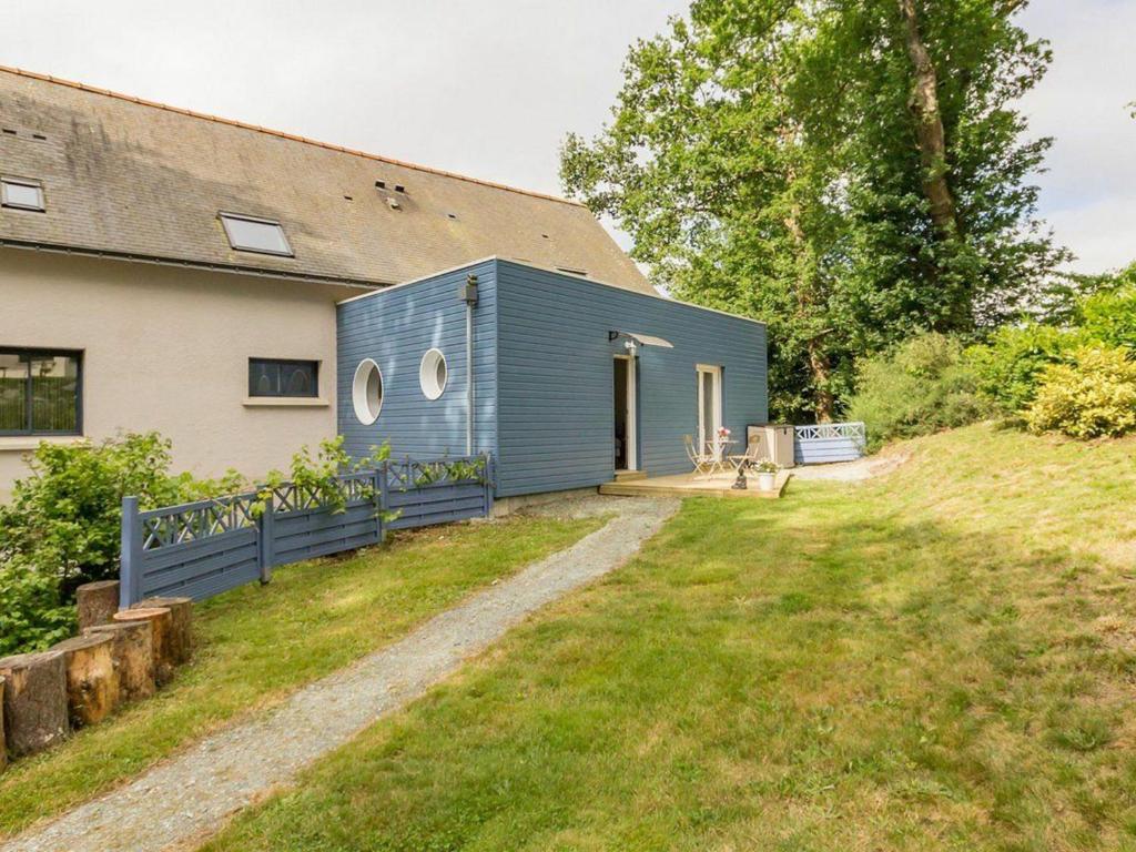 una casita azul en una colina al lado de una casa en Gîte Plesse, 1 pièce, 2 personnes - FR-1-306-835 en Plessé