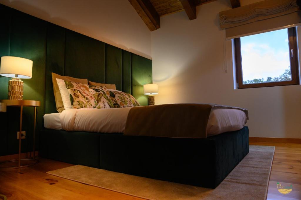 Schlafzimmer mit einem Bett mit grünen Wänden und einem Fenster in der Unterkunft PureAzibo in Macedo de Cavaleiros