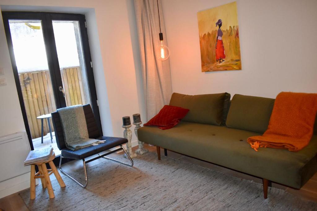 salon z zieloną kanapą i krzesłem w obiekcie Appartement Le Ponteil w mieście Les Deux Alpes