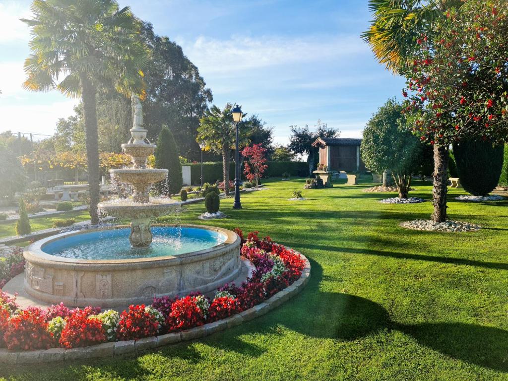 a fountain in the middle of a park with flowers at Casa de los Somoza in Melide