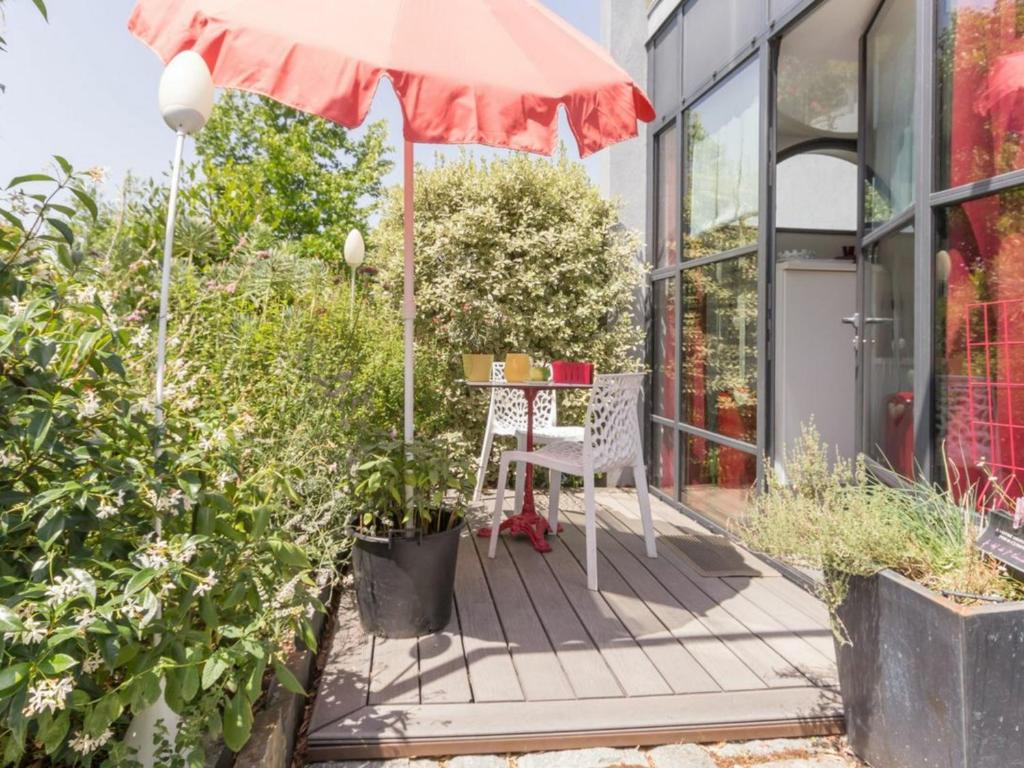 un patio con mesa y sombrilla en Gîte Nantes, 1 pièce, 2 personnes - FR-1-306-1182, en Nantes