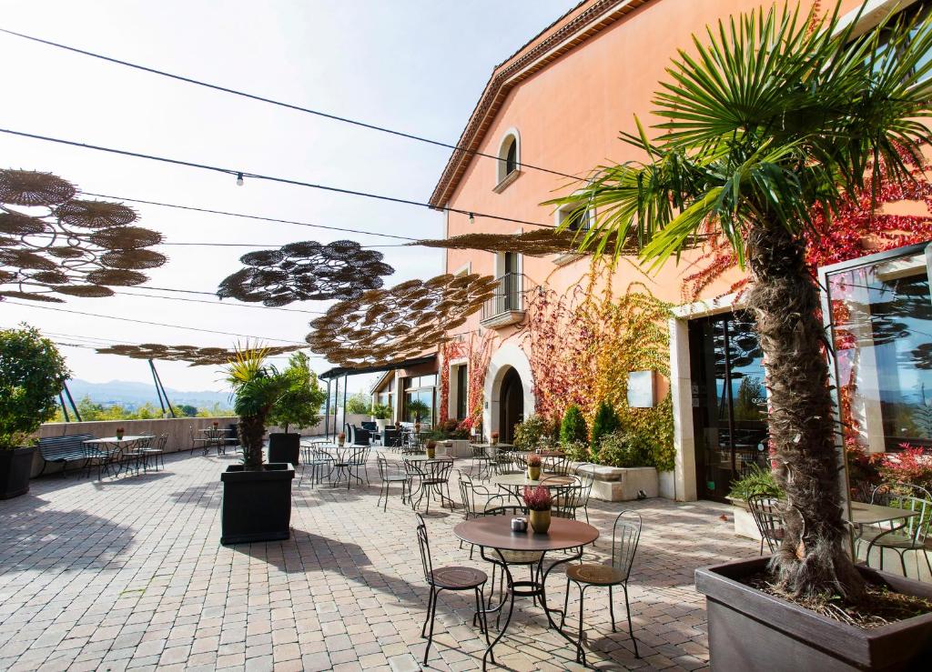 サン・クガ・デル・バリェスにあるQgat Restaurant Events & Hotelの屋外パティオ(テーブル、椅子、パラソル付)