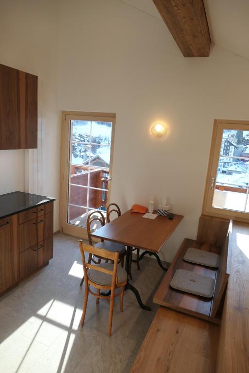 a kitchen with a wooden table and a table and chairs at Chalet Valeria in Saas-Fee