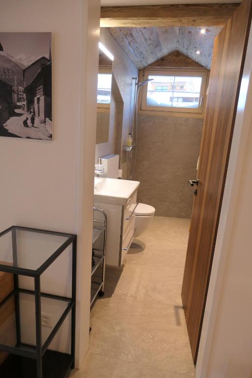 a bathroom with a sink and a toilet and a window at Chalet Valeria in Saas-Fee