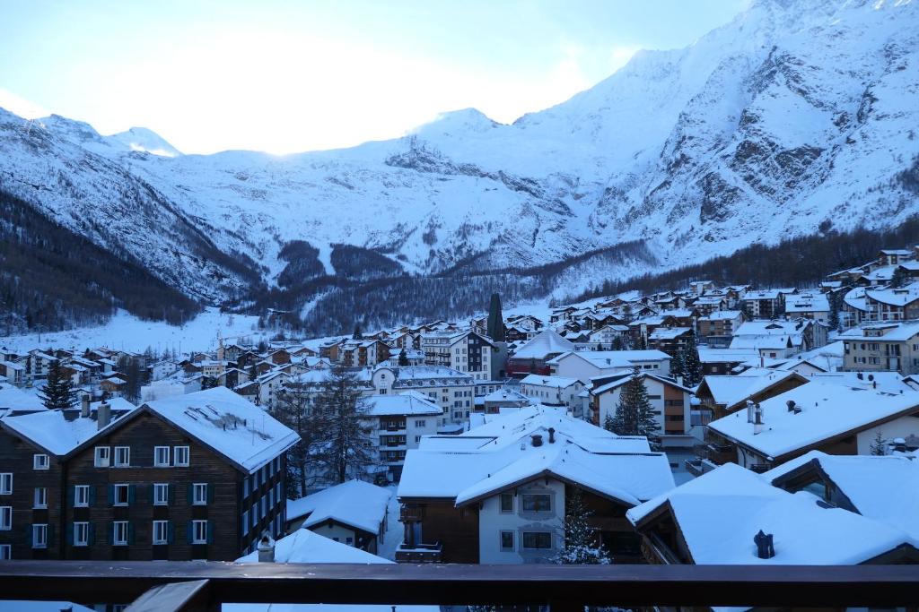 a town covered in snow with mountains in the background at Chalet Valeria in Saas-Fee