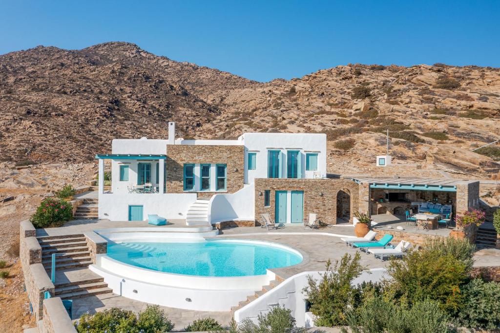 uma casa com piscina em frente a uma montanha em Magganari View Villa em Manganari