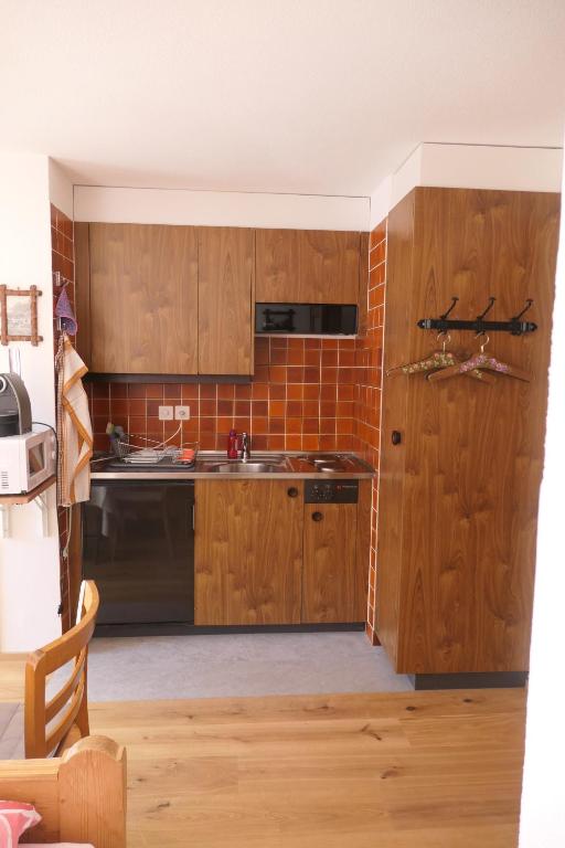 a kitchen with wooden cabinets and a sink at Chalet Valeria in Saas-Fee