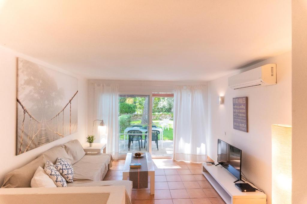 a living room with a couch and a tv at Apartamento Ferrera Park 603 in Cala Ferrera