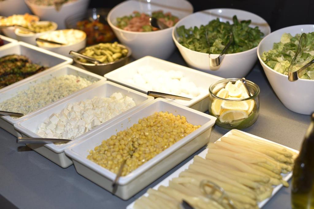 a table topped with trays of different types of food at Holiday Inn Express - Paris - CDG Airport by IHG in Roissy-en-France