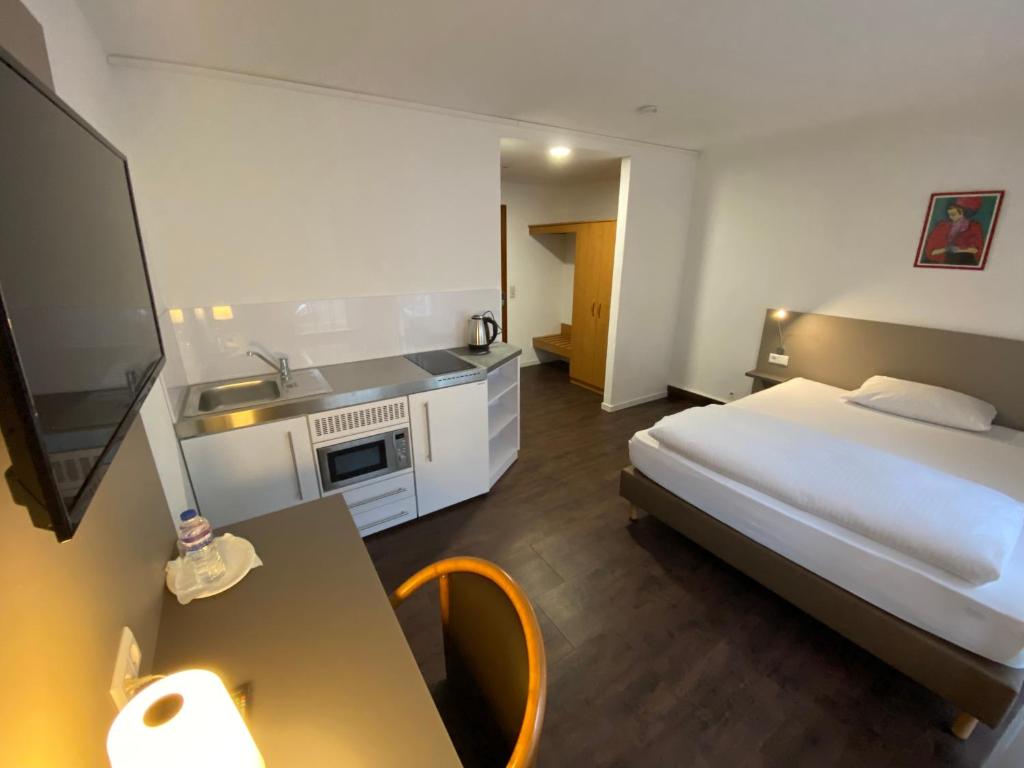 a hotel room with a bed and a television at Hotel am Schillerplatz in Pleidelsheim