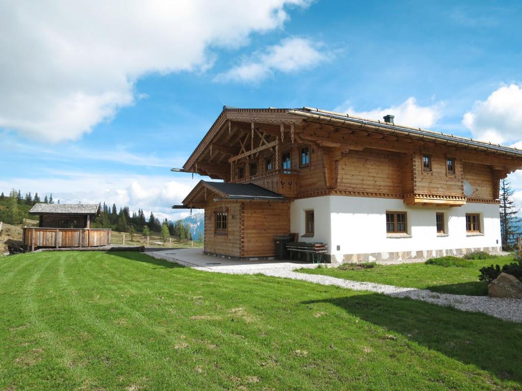 een groot houten huis met een groen gazon ervoor bij Chalet Aualm - FRT101 by Interhome in Forstau