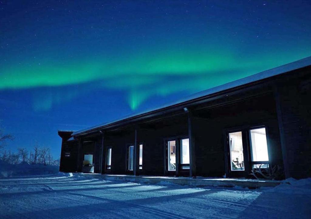 an office building with the aurora in the sky at Villa Kammi Kilpisjärvi in Kilpisjärvi