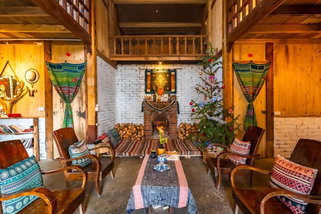 a living room with a table and chairs and a fireplace at Indi house in Sapa