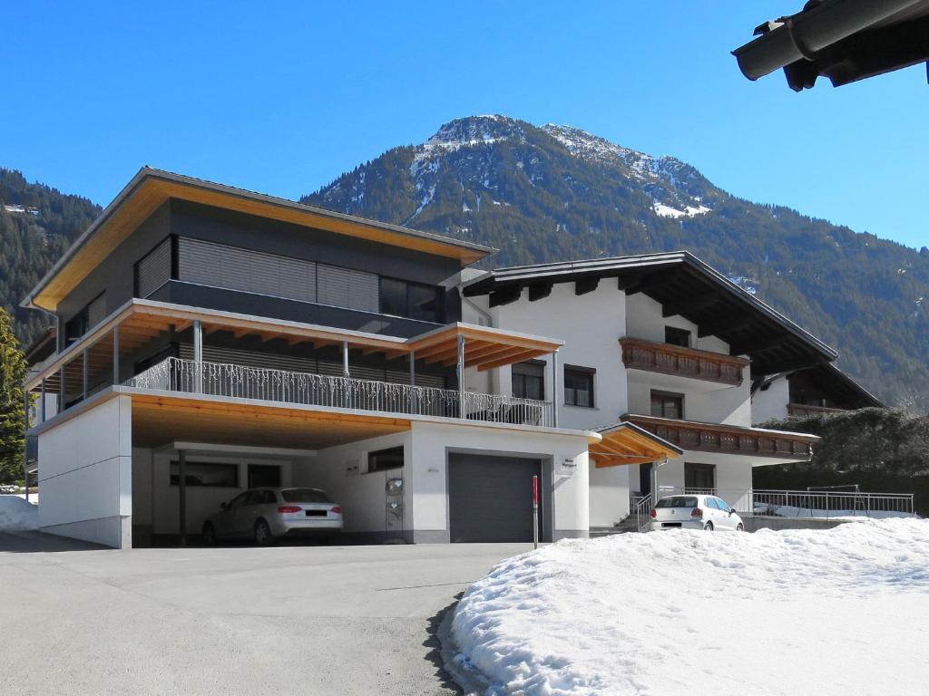 een groot gebouw met een berg op de achtergrond bij Apartment Haus Mangard - GOP210 by Interhome in Sankt Gallenkirch