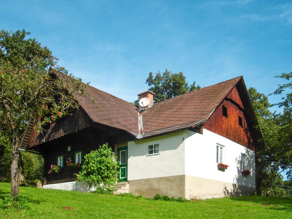 a house with a gambrel roof with a clock on it at Chalet Waldweber - SWG100 by Interhome in Kruckenberg