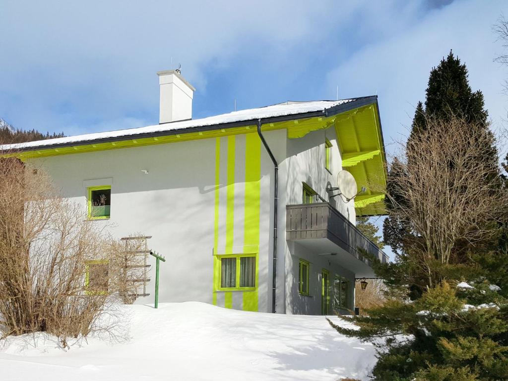 a yellow and white building with a balcony in the snow at Holiday Home Viola by Interhome in Sankt Martin am Grimming