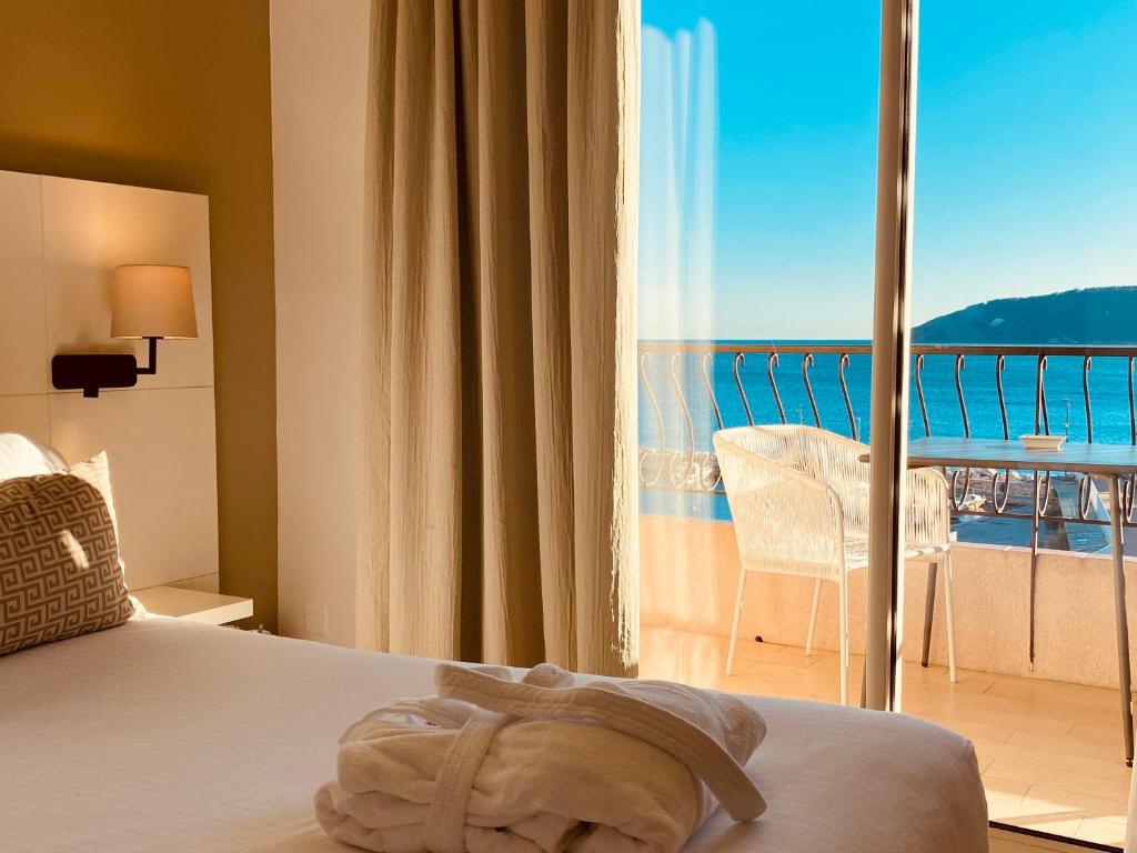 a bedroom with a bed and a view of the ocean at Best Western Plus La Corniche in Toulon